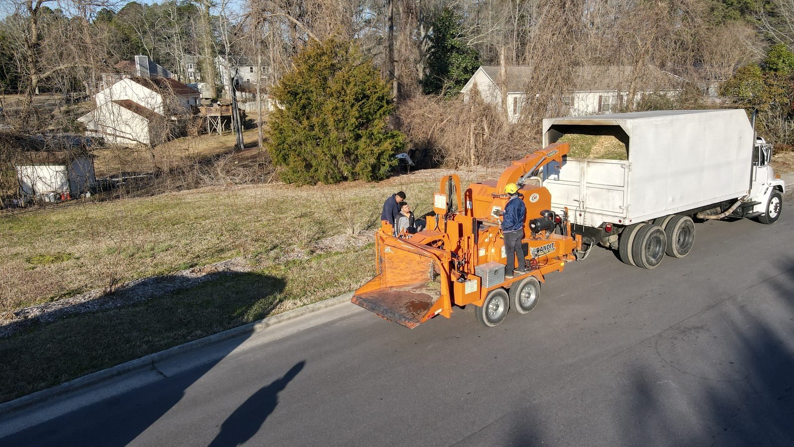 Wood chipper loading chipped brush into a truck